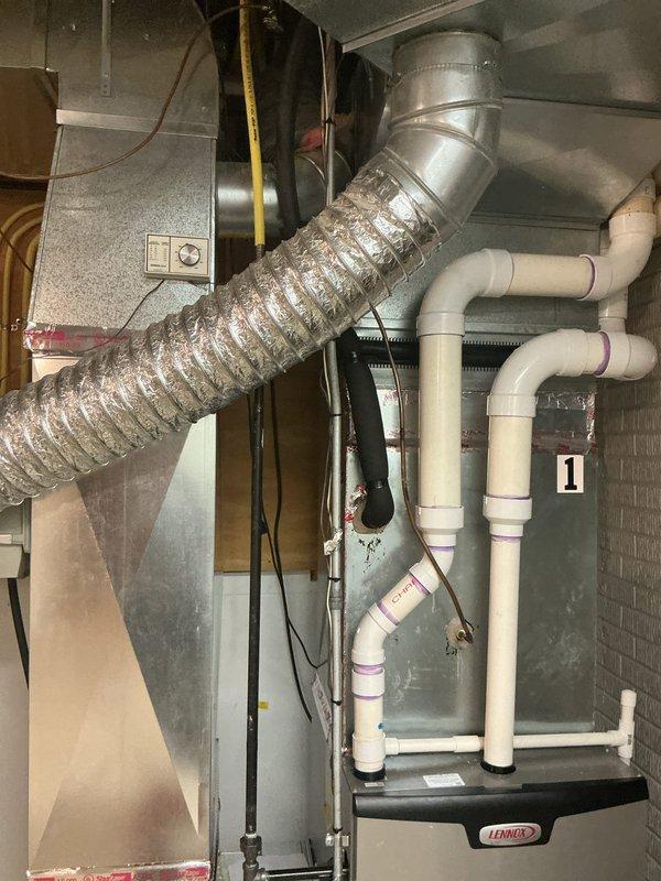 Installed new thermostat wire from the HVAC unit to the thermostat location. Routed yellow flexible conduit through ceiling joists alongside existing plumbing and electrical infrastructure, securing it properly with fasteners to wooden structural members. Connected wiring to the Lennox heating system and verified proper operation of the thermostat control circuit.