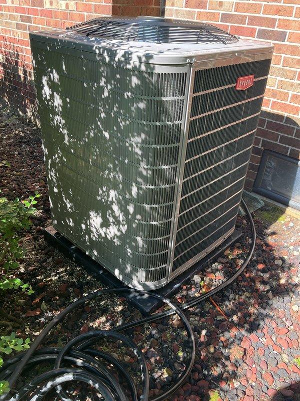 # HVAC Maintenance - Gold AC Inspection

Completed comprehensive Gold Plan preventive maintenance inspection on a 2021 Bryant air conditioning system. Performed thorough examination of outdoor condensing unit positioned against building foundation. Inspected condenser coil fins, noting moderate accumulation of organic debris and surface weathering on exterior casing. Verified refrigerant line connections and electrical conduit routing at unit base. Evaluated fan assembly and protective grille covering for proper operation. Confirmed equipment operational status with homeowner present. Documented basement-located air handler and evaporator coil accessibility. System currently functioning as designed with no immediate service requirements identified. Photographically documented equipment condition showing seasonal leaf debris accumulation around unit perimeter and exterior surface weathering patterns. All safety checks completed satisfactorily. Unit ready for continued operation with pla