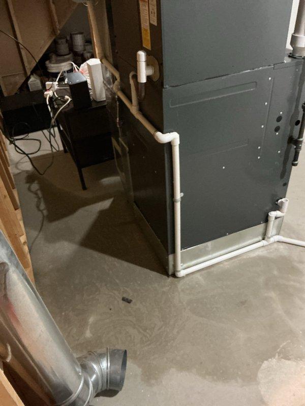 Responded to water leak complaint on 4-year-old furnace located in basement. Upon arrival, unit was operational and maintaining heat. Inspected furnace and associated condensate drainage system, including white PVC piping configuration. Examined condensate trap, drain lines, and connections for blockages or improper pitch. Verified primary and secondary drain line routing and functionality. Checked evaporator coil area for excessive condensation or overflow conditions. Assessed furnace operation and cycling to identify source of water accumulation. Return visit scheduled to complete diagnostics and repairs during warmer ambient temperatures for optimal system evaluation.