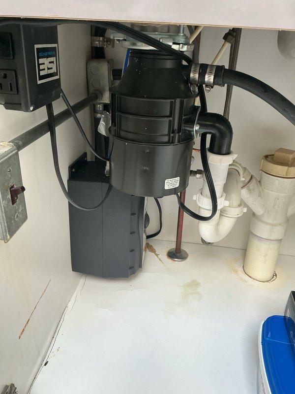 Responded to slow-draining kitchen sink in 30-year-old residence. Upon inspection, found stainless steel sink basin with visible mineral deposits and water spotting, indicating drainage issues isolated to kitchen area only. Accessed under-sink plumbing system and inspected garbage disposal unit, drain lines, and PVC waste connections. Identified partial obstruction causing reduced flow rate over 2-3 day period. Cleared blockage from drain line using appropriate mechanical methods. Verified proper drainage function of disposal unit and confirmed all connections secure with no leaks present. Tested system flow rate and restored full drainage capacity to kitchen sink.