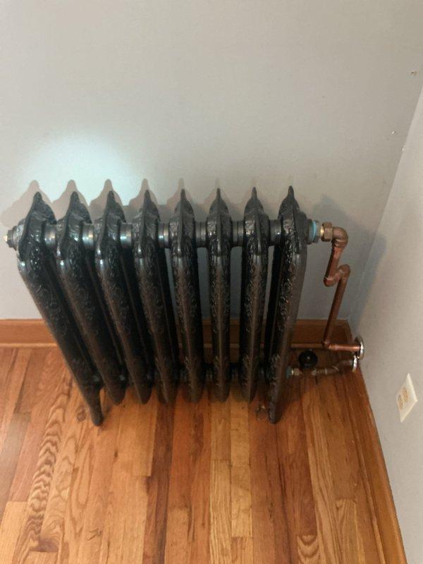 Delivered replacement radiator to property and conducted inspection of hydronic heating system. Identified defective radiator unit requiring swap or repair and discovered leaking threads on secondary unit requiring re-tapping with 1.25" tap. Assessed aging boiler system and recommended installation of 1" press ball valve near boiler to facilitate zone bleeding operations and replacement of deteriorated 3/4" boiler drain. Customer will contact manufacturer customer service regarding warranty coverage before scheduling return visit to complete repairs. Documented existing conditions including corroded copper piping, aging circulation pump with visible oxidation, and moisture staining near valve assembly. Awaiting customer confirmation to proceed with unit replacement, thread repair, and recommended system upgrades.