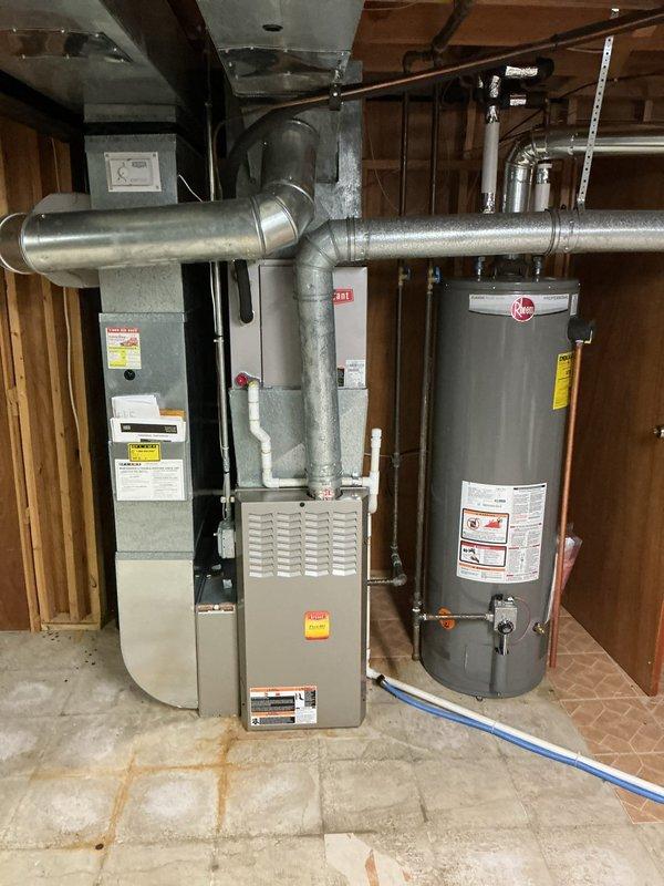 Completed comprehensive Gold AC inspection on 10+ year old residential air conditioning system with air handler located in basement. Performed thorough visual inspection of HVAC equipment, ductwork, and associated components including furnace unit and metallic duct system. Verified system operational status, documented equipment condition through photographic records, and confirmed proper clearance around condenser unit. All equipment found to be in working order at time of inspection.