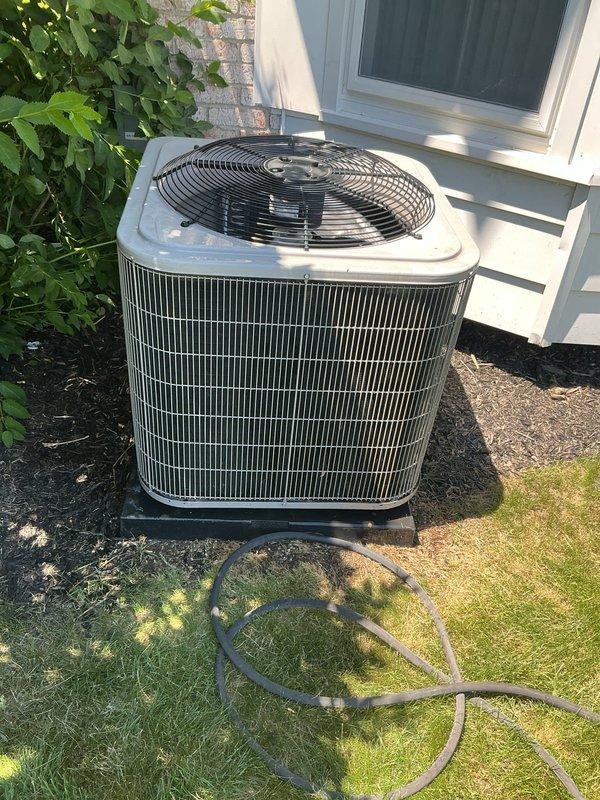 Completed comprehensive Gold AC Inspection on a 4-year-old single-unit air conditioning system with basement-located air handler. Performed thorough examination of outdoor condenser unit, verified proper operation of fan assembly and louvered panels, and inspected all accessible components including refrigerant lines, electrical connections, and condensate drainage. Documented equipment condition through photographic records showing condenser unit positioned on concrete pad with adequate clearance and proper mulch landscaping for drainage. All systems found to be operational and functioning within normal parameters at time of inspection.