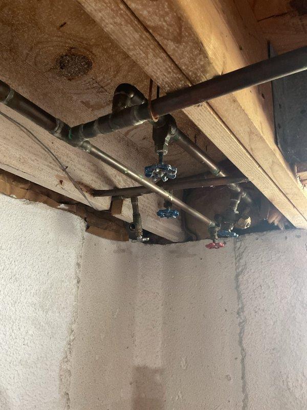 Conducted on-site evaluation of existing plumbing infrastructure to provide estimate for battery backup sump pump installation. Inspected exterior water supply lines with shutoff valves and interior basement plumbing system including copper supply lines with isolation valves. Documented current conditions of outdoor hose bibs, main water connections, and basement water distribution system. Photographed existing plumbing configuration to develop comprehensive proposal for backup pump system integration with current infrastructure.