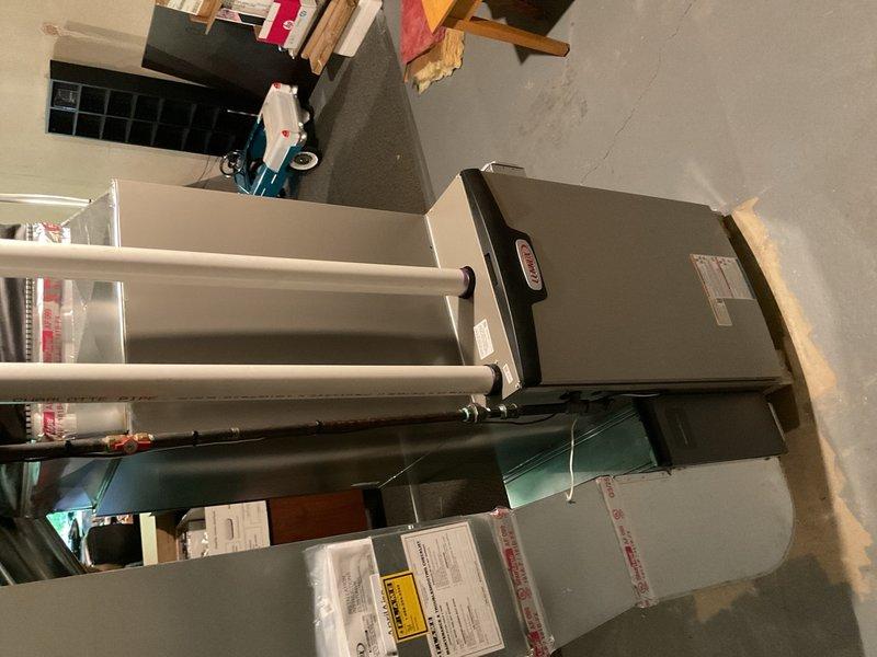 Completed full HVAC system installation including a 90,000 BTU high-efficiency furnace and 3-ton air conditioning unit with rear discharge configuration. Installed new ductwork routing through basement floor joists with proper support and sealing, connected galvanized metal ducting with flexible transitions as needed. Mounted air handler in utility area with appropriate clearances for service access and code compliance. Installed humidifier system integrated with furnace operation and established proper condensate drainage using PVC piping. Reconnected all electrical, plumbing, and mechanical components to ensure proper system operation. Requested and coordinated mechanical, plumbing, and electrical permits for the installation. System was configured to meet AHRI certification standards and qualified for applicable utility rebates. All equipment installed per manufacturer specifications with proper venting, drainage, and safety controls verified operational.