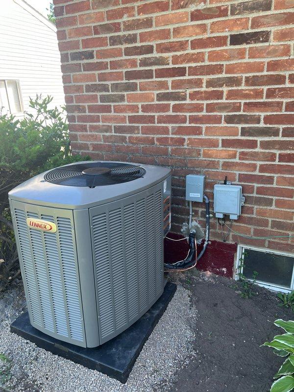 Successfully completed installation of a 2.5-ton Lennox air conditioning system with evaporator coil at residential property. Positioned new condenser unit on rubber isolation pad with gravel base against rear exterior brick wall, installed electrical disconnect box and conduit with proper wiring connections to building exterior. Interior work included evaporator coil installation integrated with existing Lennox furnace system in mechanical room, with PVC condensate drainage lines and refrigerant line connections completed. Performed electrical reconnection of all components, tested system operation, and verified proper refrigerant charge and airflow. Permits requested for mechanical, electrical, and air conditioning work per local code requirements. All equipment installed per manufacturer specifications with proper clearances maintained, system fully operational upon completion.