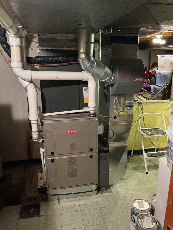 Completed comprehensive Gold AC Inspection on 3-year-old Bryant HVAC system located in basement. Performed full system evaluation including inspection of furnace unit, ductwork connections, PVC drainage and venting lines, and verified proper thermostat operation with system maintaining 71°F room temperature. All components found to be functioning properly with no immediate service needs identified at time of inspection.