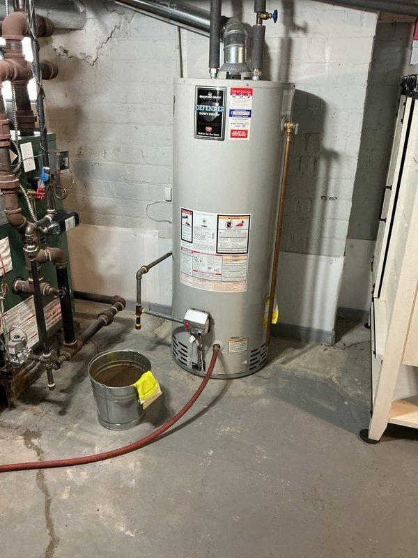Responded to service call for tanked water heater producing popping noise in basement. Upon inspection, diagnosed sediment buildup at bottom of tank causing characteristic popping sounds during heating cycles. Performed tank flush procedure by connecting drain hose to drain valve, opening pressure relief valve, and draining accumulated sediment and mineral deposits from unit. Verified all copper supply lines, valves, and connections for proper operation and absence of leaks. Restored unit to normal operation with reduced noise levels.