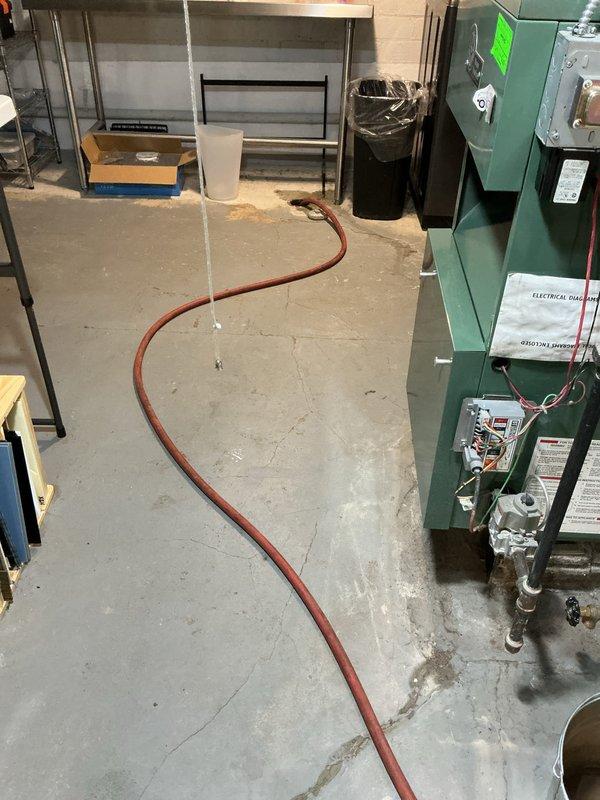 Responded to service call for tanked water heater producing popping noise in basement. Upon inspection, diagnosed sediment buildup at bottom of tank causing characteristic popping sounds during heating cycles. Performed tank flush procedure by connecting drain hose to drain valve, opening pressure relief valve, and draining accumulated sediment and mineral deposits from unit. Verified all copper supply lines, valves, and connections for proper operation and absence of leaks. Restored unit to normal operation with reduced noise levels.