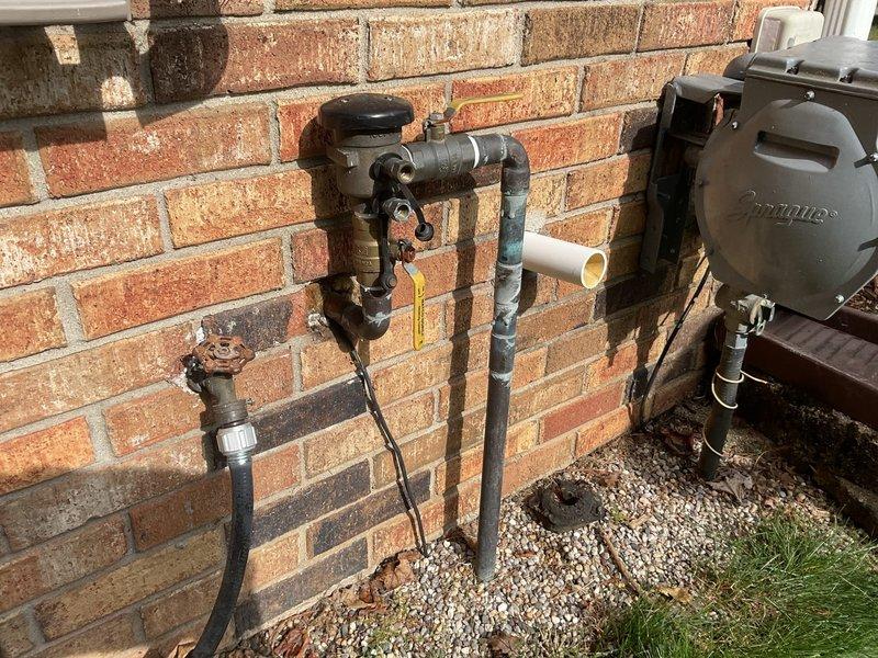 Responded to water leak at pressure vacuum breaker (PVB) assembly on east side of residential property. Upon arrival, identified active leak at female brass union connection between PVB and main water supply line, which began when water was restored that morning. Inspected corroded plumbing assembly mounted on exterior brick wall, noting significant rust and deterioration on metal components and water staining on surrounding masonry. Repaired faulty connection at brass union fitting to eliminate leak and restore proper seal. Verified system integrity and confirmed leak was isolated to this connection point with no impact to interior plumbing. Tested water flow after repair to ensure proper operation of PVB and supply line without further leakage.