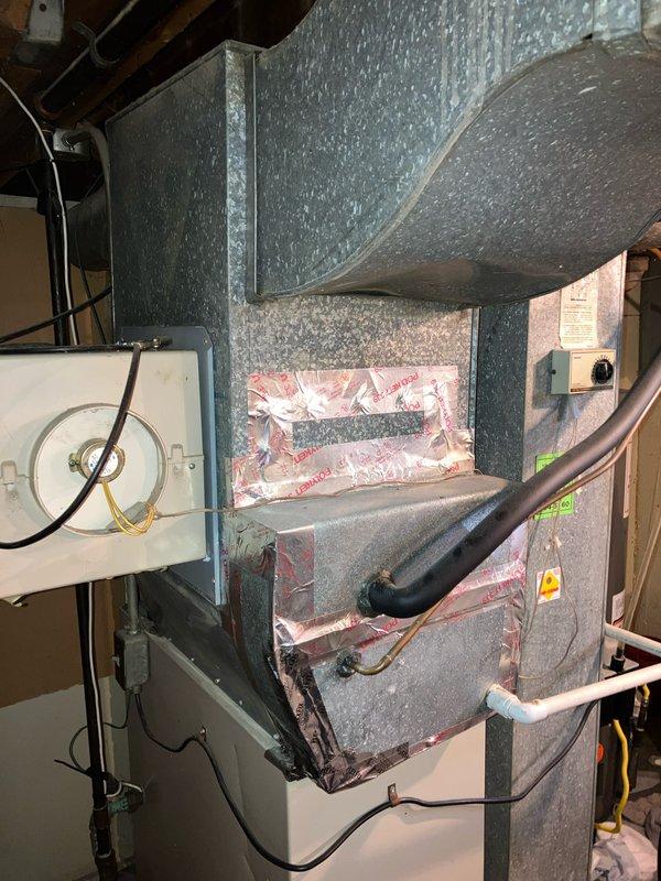 Conducted on-site evaluation for air conditioning system replacement at residential property. Assessed existing outdoor condensing unit positioned on concrete pad along exterior brick wall, noting copper refrigerant lines, electrical disconnect box, and overall system configuration. Documented indoor air handler and ductwork assembly in basement mechanical room to determine compatibility requirements for replacement equipment and provide comprehensive replacement estimate.