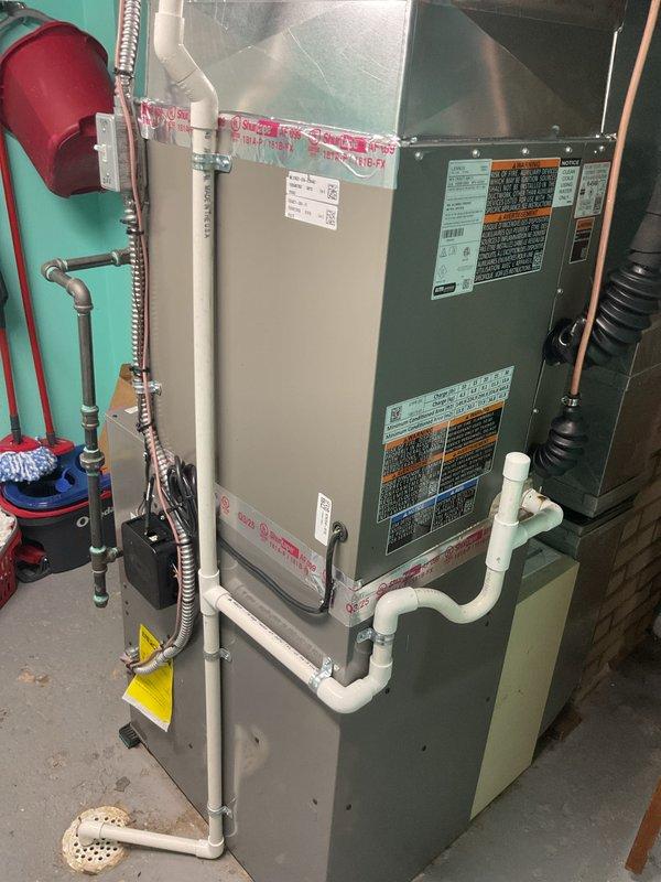 Completed installation of 2.5-ton air conditioning system with evaporator coil replacement. Outdoor condensing unit (Lennox model) was upgraded from originally specified equipment due to availability constraints, with all parties approving the substitution prior to installation. Unit mounted on composite pad with proper clearances, connected via copper refrigerant lines and electrical conduit to new disconnect box. Indoor evaporator coil installed in basement mechanical room with PVC condensate drainage properly routed. System evacuated, charged to manufacturer specifications, and tested for proper operation. Electrical work noted as requiring licensed electrician for final connections and code compliance. Mechanical, electrical, and air conditioning permits secured prior to commencement of work. All refrigerant lines insulated, system operational upon completion of electrical hookup.