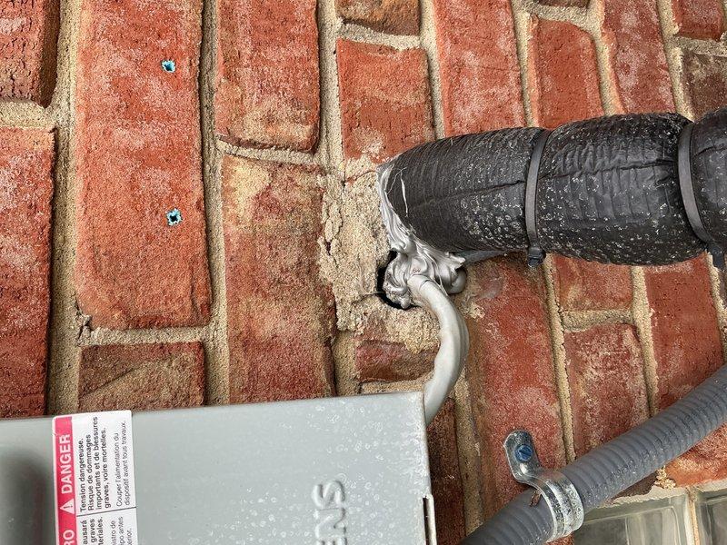 Completed annual air conditioning inspection and tune-up on 4-year-old Bryant condensing unit located on exterior brick paver patio with evaporator coil in basement. Performed standard maintenance protocol including system performance verification, refrigerant charge assessment, and electrical connections inspection. Sealed electrical penetration point at exterior wall where conduit enters structure to prevent moisture infiltration and pest entry, addressing weatherization concern identified during initial service request.