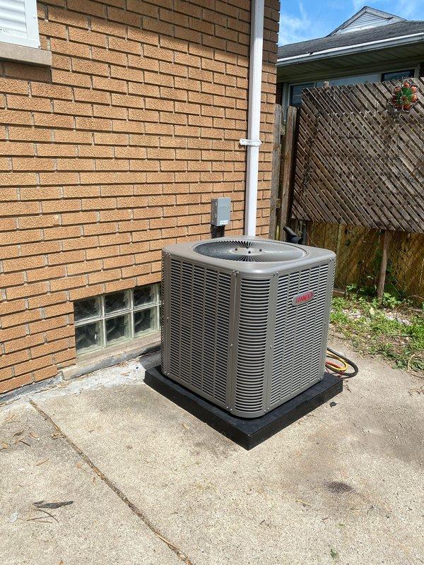 Completed installation of 2.5-ton Lennox air conditioning system with evaporator coil at residential property. The original specified A/C model was unavailable, requiring an upgraded unit substitution that was approved by all parties prior to installation. Unit was positioned on concrete pad with vibration-dampening mount against rear exterior wall. Connected refrigerant lines, established electrical service with disconnect box mounted to structure, and reconnected all necessary components. System was tested for proper operation, airflow, and refrigerant charge. Installation included permit request for mechanical and AC work. All connections secured and system left in full operational status.
