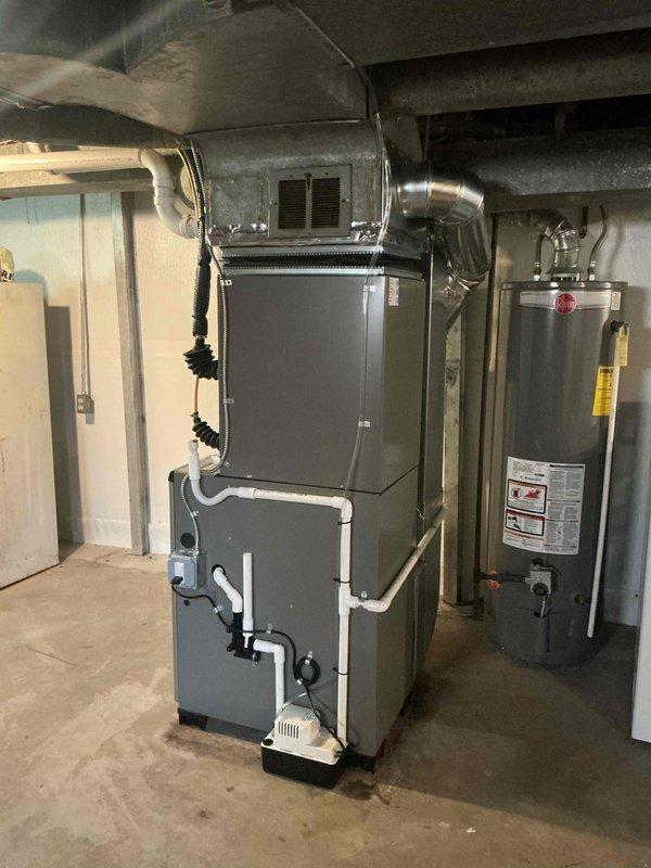 Completed full HVAC system installation including a 70,000 BTU furnace and 2.5 ton rear-discharge air conditioning unit in basement mechanical room. Installed new thermostat, humidifier, and furnace liner, reconnected all ductwork with proper metallic flexible ducting, and integrated white PVC condensate drainage system. Coordinated electrical work requirements and obtained mechanical and electrical permits for the installation, with utility rebate documentation processed and AHRI certificate number recorded for system efficiency verification.