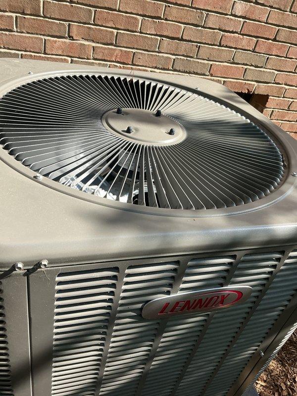 Completed comprehensive Gold AC inspection on a 1-year-old Lennox two-unit residential system with air handler located in basement. Performed thorough examination of outdoor condensing unit, verified proper operation of fan assembly and compressor, inspected ventilation slats and housing for adequate airflow, confirmed unit is free of debris and maintaining proper clearances from structure. All components found to be in excellent condition with no visible damage, rust, or deterioration, and system operating within normal parameters.