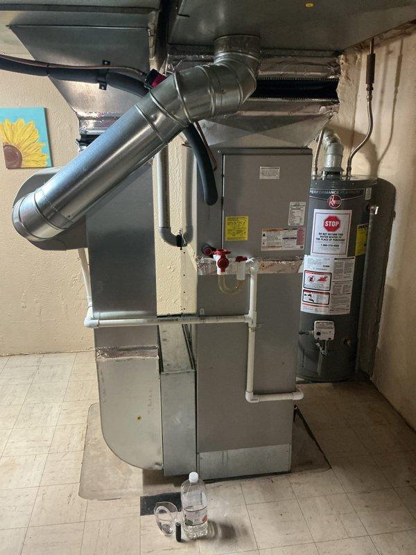Completed comprehensive Gold AC inspection on 9-year-old residential air conditioning system with air handler located in basement and condenser unit positioned on exterior concrete pad. Performed thorough multi-point inspection including visual assessment of indoor furnace/air handler unit with associated ductwork and outdoor condensing unit. Verified system operational status, examined electrical connections at outdoor disconnect, inspected refrigerant lines, and assessed overall equipment condition. Checked condenser coil cleanliness, confirmed proper clearances around outdoor unit, and evaluated air handler cabinet and duct connections in basement mechanical room. Documented equipment specifications and manufacturer labeling on both indoor and outdoor components. System found to be operational with no immediate service concerns identified during inspection. Homeowner requested filter replacement and humidifier pad replacement as part of routine maintenance service.