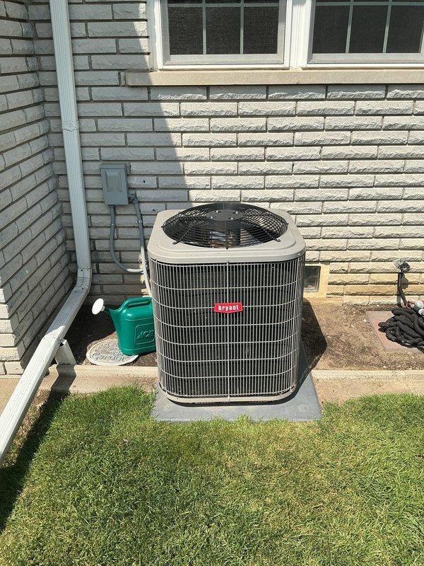 Completed comprehensive Gold AC inspection on 9-year-old residential air conditioning system with air handler located in basement and condenser unit positioned on exterior concrete pad. Performed thorough multi-point inspection including visual assessment of indoor furnace/air handler unit with associated ductwork and outdoor condensing unit. Verified system operational status, examined electrical connections at outdoor disconnect, inspected refrigerant lines, and assessed overall equipment condition. Checked condenser coil cleanliness, confirmed proper clearances around outdoor unit, and evaluated air handler cabinet and duct connections in basement mechanical room. Documented equipment specifications and manufacturer labeling on both indoor and outdoor components. System found to be operational with no immediate service concerns identified during inspection. Homeowner requested filter replacement and humidifier pad replacement as part of routine maintenance service.