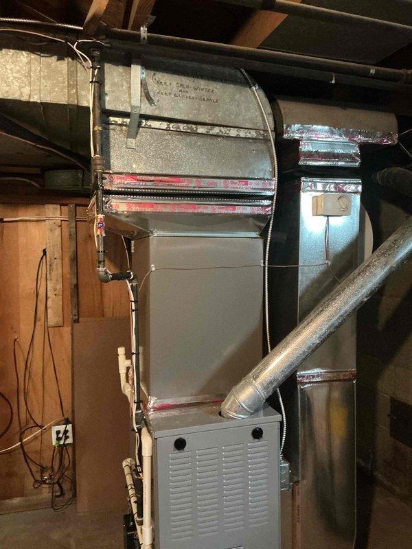 Completed installation of new air conditioning system and evaporator coil in residential basement location. Installed air handler unit with proper refrigerant line connections, integrated with existing furnace and ductwork infrastructure. Routed copper refrigerant lines vertically through mechanical space, ensuring proper insulation and support. Connected new coil to supply plenum with appropriate sealing and insulation at connection points. Verified all electrical connections, tested system operation, and confirmed proper airflow through ductwork. Permit requested for installation as required by local code.
