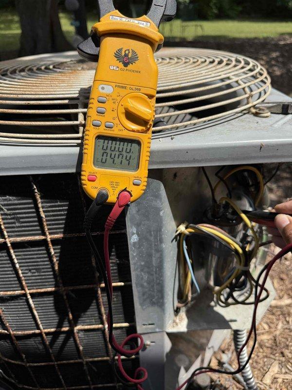 Completed comprehensive Gold AC inspection on 30-year-old single-zone air conditioning system with air handler located in basement. Performed electrical diagnostics on outdoor condensing unit using digital multimeter, testing amperage draw and verifying proper electrical operation. Inspected condenser coil condition, noting spiral copper tubing configuration and protective wire guard integrity. Examined compressor motor and associated electrical components, including dual-run capacitor rated at 45+5µF at 440VAC. Verified all electrical connections, including service panel wiring and control circuits. Assessed overall system operation and confirmed unit is functioning properly despite advanced age of equipment. All components inspected and found operational at time of service.