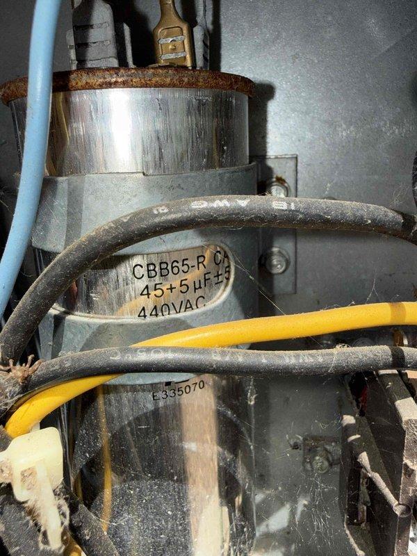 Completed comprehensive Gold AC inspection on 30-year-old single-zone air conditioning system with air handler located in basement. Performed electrical diagnostics on outdoor condensing unit using digital multimeter, testing amperage draw and verifying proper electrical operation. Inspected condenser coil condition, noting spiral copper tubing configuration and protective wire guard integrity. Examined compressor motor and associated electrical components, including dual-run capacitor rated at 45+5µF at 440VAC. Verified all electrical connections, including service panel wiring and control circuits. Assessed overall system operation and confirmed unit is functioning properly despite advanced age of equipment. All components inspected and found operational at time of service.