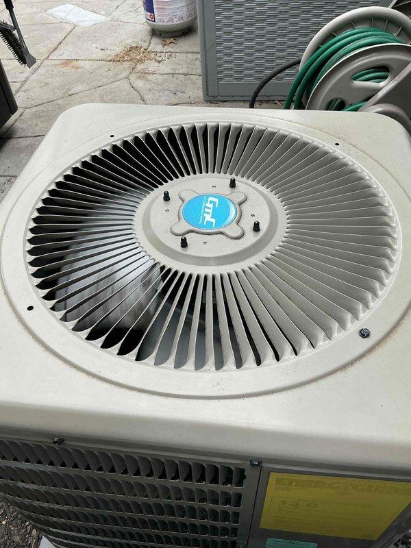 Responded to service call for central air conditioning system experiencing inadequate cooling and ice formation on refrigerant lines. Upon arrival, conducted visual inspection of outdoor condenser unit and associated components. Observed ice buildup on suction line, indicating potential refrigerant flow restriction or low charge condition. Checked system operation and verified unit was running but not achieving proper cooling capacity. Inspected condenser coil, fan operation, and electrical connections. Evaluated refrigerant line insulation and condensate drainage system. Documented equipment condition through photographs showing outdoor heat pump unit on concrete pad with PVC condensate piping, insulated refrigerant lines, and top-mounted fan assembly. Unit appeared in generally well-maintained condition with no visible signs of significant physical damage or corrosion. Identified ice formation issue as likely caused by restricted airflow, low refrigerant charge, or metering device ma