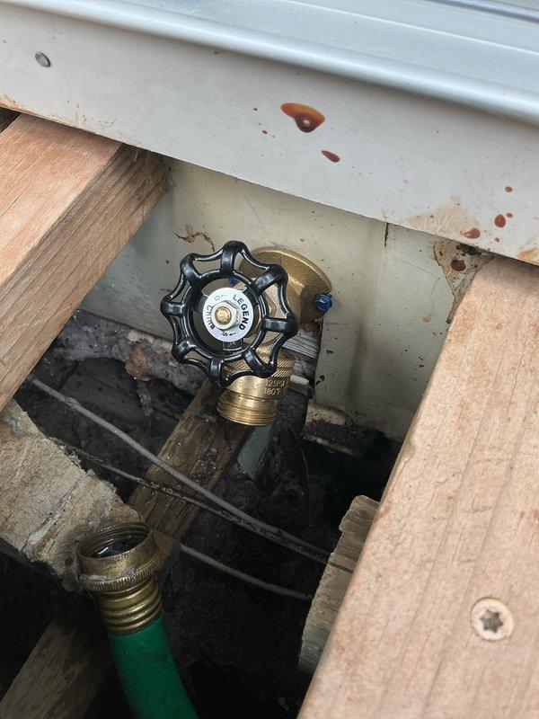 Replaced corroded outdoor spigot that had deteriorated and detached from the property. Installed new brass gate valve with star-shaped handle and secured all connections through the foundation access point beneath the exterior window. Tested system for proper water flow and verified no leaks at valve body, threaded fittings, or hose connection points.