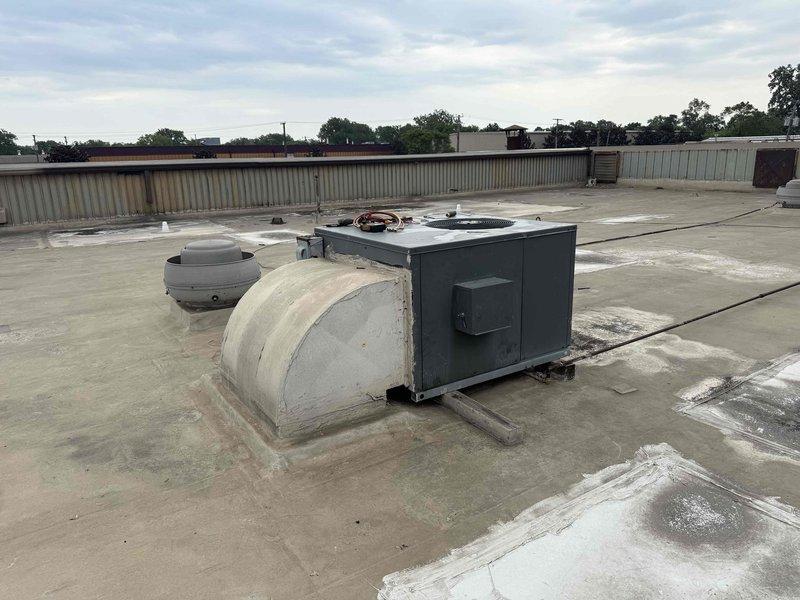 Responded to no cooling complaint on rooftop RTU unit with reported lack of airflow. Upon inspection, confirmed compressor and refrigerant system components present but identified potential blower motor failure preventing air circulation through the system. Accessed unit via ladder on commercial roof, documented internal mechanical components including compressor, control relay, heat exchanger coils, and associated refrigerant piping showing normal wear and oxidation consistent with unit age.
