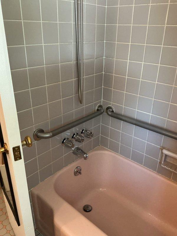 Responded to service call for leaking copper pipe in attic space and dripping bathtub faucet. Inspected copper supply line running through upper level structural area and identified source of leak. Assessed tub/shower fixture with chrome handles and spout in tiled bathroom, diagnosed worn valve seat causing persistent drip, and performed necessary repairs to restore proper function and eliminate water waste.
