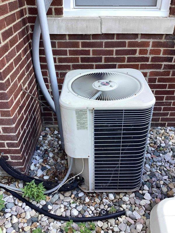 Completed comprehensive estimate inspection for residential HVAC system replacement involving a 1999 air conditioning unit with air handler located in attic and outdoor condenser positioned at exterior foundation. System evaluation revealed failing compressor on outdoor unit, with capacitor having been recently replaced during previous service call. Performed Gold-level inspection protocol including visual assessment of both indoor and outdoor components, documented equipment condition through photographic evidence showing condenser unit with visible wear on exterior casing and attic-mounted air handler with accessible return grille. Provided homeowner with replacement options and system specifications for complete HVAC system upgrade due to age of equipment and compressor failure requiring full unit replacement rather than repair.