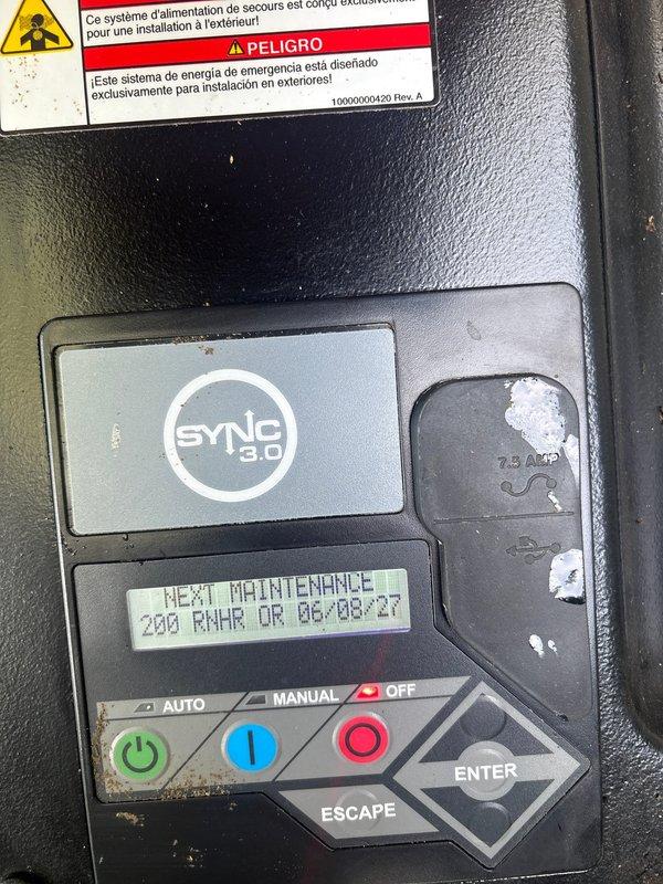 Completed annual maintenance inspection on 22kW Honeywell standby generator per maintenance plan requirements. Inspected control panel displaying SYNC 3.0 interface, verified system status showing next scheduled maintenance at 200 run hours, and confirmed all operational modes (Auto/Manual/Off) functioning properly. Examined air filtration system, noting filter dated 6-8-2024 in serviceable condition, and documented mechanical components including ductwork, connections, and safety warning labels all present and intact.
