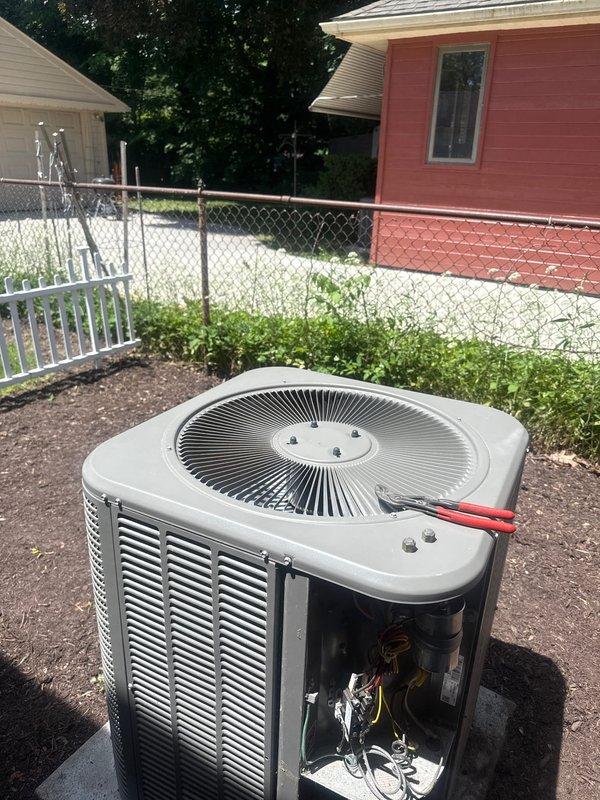 Performed comprehensive tune-up and maintenance on a 9-year-old outdoor air conditioning condenser unit. Inspected all accessible internal components including electrical connections, wiring harness, and mechanical assemblies with side panel removed for thorough evaluation. Verified refrigerant line connections, examined fan assembly and grille operation, and confirmed proper unit mounting on concrete pad, with system showing normal operating condition and no issues identified during inspection.