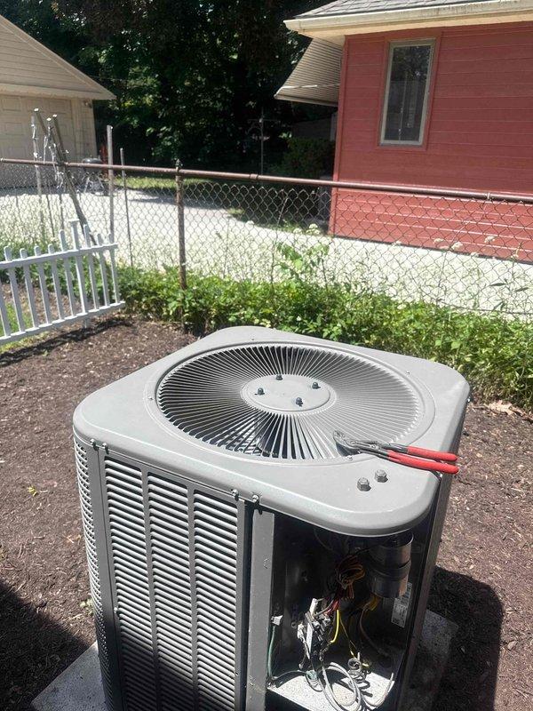 Performed comprehensive tune-up and maintenance on a 9-year-old outdoor air conditioning condenser unit. Inspected all accessible internal components including electrical connections, wiring harness, and mechanical assemblies with side panel removed for thorough evaluation. Verified refrigerant line connections, examined fan assembly and grille operation, and confirmed proper unit mounting on concrete pad, with system showing normal operating condition and no issues identified during inspection.