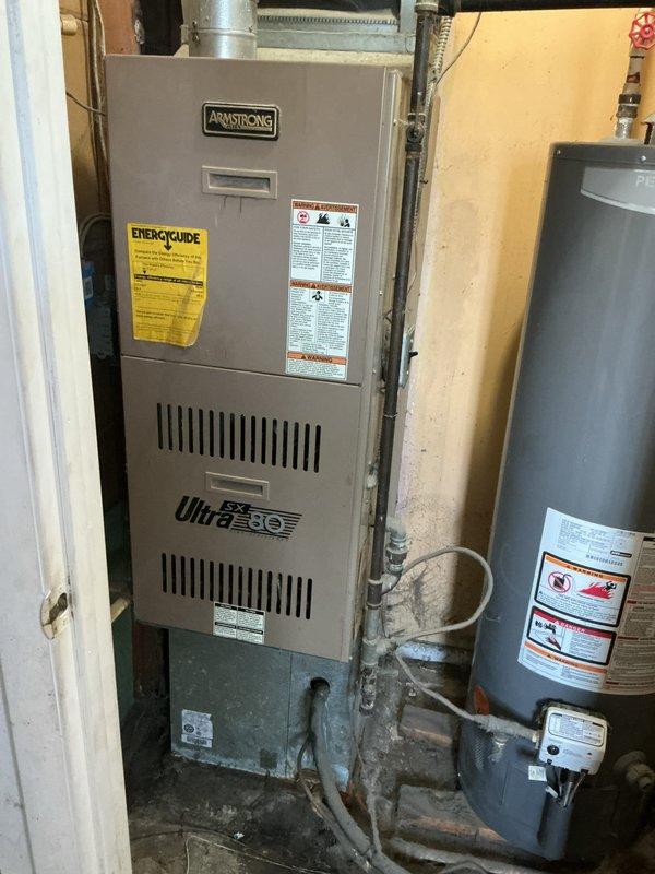 Completed comprehensive estimate for replacement of existing 30-year-old air conditioning unit and Armstrong UltraSX furnace system at owner-occupied single-family residence. Evaluated current HVAC equipment including exterior condenser unit located behind home and interior furnace installation with associated ductwork and plenum chamber. Documented existing system configuration through photographic assessment showing furnace unit, cylindrical metal plenum with galvanized ductwork, and overall mechanical room layout to provide accurate replacement specifications.