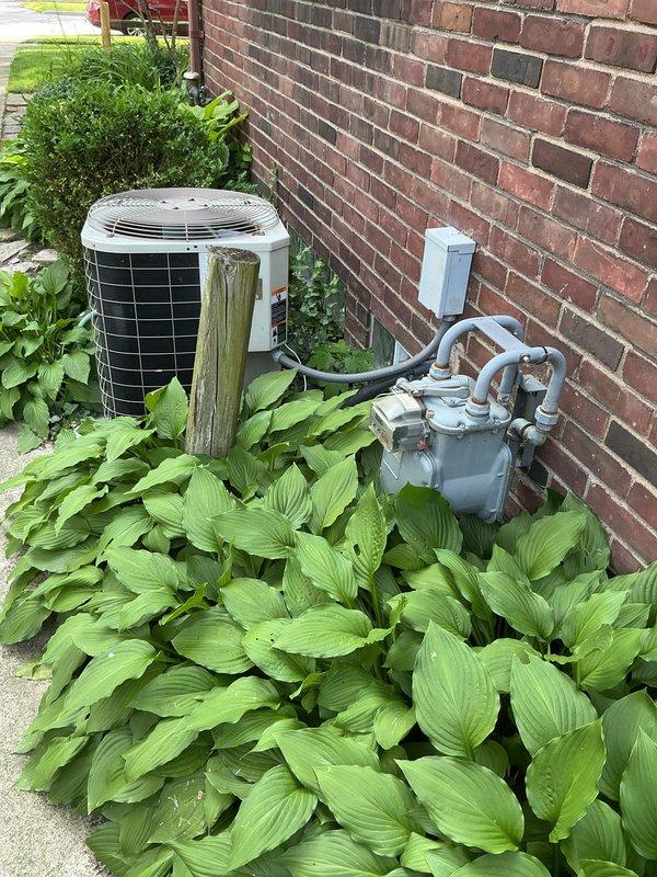 Completed comprehensive estimate for HVAC system replacement at residential property with aging equipment including a 2005 condenser unit and 1995 evaporator coil currently low on R22 refrigerant. Assessment included evaluation of existing cylindrical air conditioning condenser positioned on concrete pad against exterior brick wall, basement-located air handler/coil assembly, and malfunctioning humidifier system requiring replacement. Documented equipment conditions through photographic inspection and provided replacement recommendations for complete system upgrade to address refrigerant phase-out concerns and resolve ongoing humidifier issues.
