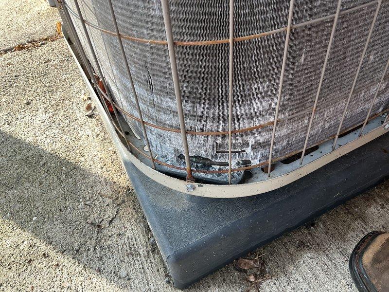 Performed comprehensive AC tune-up on aging outdoor condenser unit located in garage area of condominium. Conducted standard maintenance procedures including inspection of compressor, condenser coils, refrigerant lines, and fan motor assembly. Unit exhibited moderate accumulation of dirt and debris on condenser fins, with visible rust and corrosion present at base mounting points and wire guard framework, consistent with extended outdoor exposure. Verified electrical connections, assessed refrigerant line integrity, and evaluated overall system operation. No immediate repairs required; unit operational at time of service completion.