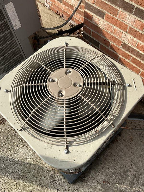 Performed comprehensive AC tune-up on aging outdoor condenser unit located in garage area of condominium. Conducted standard maintenance procedures including inspection of compressor, condenser coils, refrigerant lines, and fan motor assembly. Unit exhibited moderate accumulation of dirt and debris on condenser fins, with visible rust and corrosion present at base mounting points and wire guard framework, consistent with extended outdoor exposure. Verified electrical connections, assessed refrigerant line integrity, and evaluated overall system operation. No immediate repairs required; unit operational at time of service completion.