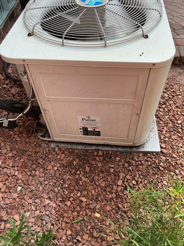 Performed comprehensive inspection and tune-up on Pabon brand outdoor condensing unit. Unit found in functional condition with fan assembly operating properly and protective grille intact. Verified proper placement on concrete pad, noted minor vegetation growth in surrounding gravel area that should be monitored to prevent airflow obstruction.
