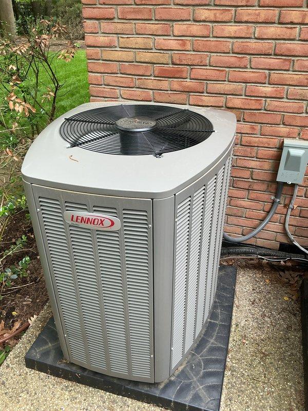 Completed comprehensive Gold AC inspection on residential property with three air conditioning units, including one Bryant and one Lennox condensing unit located exterior on concrete pads, with air handler/coil assembly positioned in basement. Performed thorough visual assessment of all accessible components, verified operational status of equipment less than 10 years old, and documented unit conditions through photographic evidence. Inspected exterior condensing units for proper airflow clearances, examined mounting pads and electrical disconnect boxes, assessed cabinet integrity and louver vent conditions, and verified fan guard assemblies were intact. Noted minor dirt accumulation on equipment surfaces consistent with normal outdoor exposure and identified debris around condenser base areas requiring clearance to maintain optimal performance and prevent airflow restrictions.