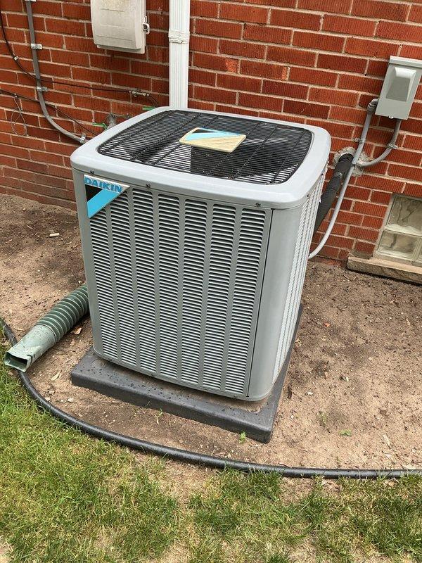 Completed comprehensive Gold AC inspection on 7-year-old Daikin condenser unit located on exterior concrete pad. Accessed property through side door as requested. Performed multi-point inspection including visual assessment of condenser cabinet, louvers, and fan assembly with protective grille. Inspected electrical connections, disconnect box, and conduit routing on exterior wall. Evaluated refrigerant line set condition and drainage system including corrugated discharge hose. Confirmed proper unit placement on pad and assessed concrete pad condition. Verified all external components, mounting hardware, and connections for proper operation and wear. Unit found in satisfactory operating condition with no immediate service concerns identified.