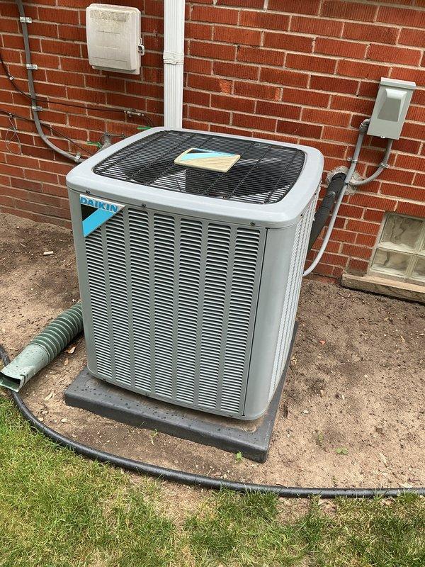 Completed comprehensive Gold AC inspection on 7-year-old Daikin condenser unit located on exterior concrete pad. Accessed property through side door as requested. Performed multi-point inspection including visual assessment of condenser cabinet, louvers, and fan assembly with protective grille. Inspected electrical connections, disconnect box, and conduit routing on exterior wall. Evaluated refrigerant line set condition and drainage system including corrugated discharge hose. Confirmed proper unit placement on pad and assessed concrete pad condition. Verified all external components, mounting hardware, and connections for proper operation and wear. Unit found in satisfactory operating condition with no immediate service concerns identified.