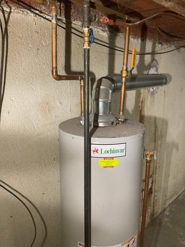 Installed 40-gallon Lochinvar tanked water heater in basement utility area. Completed all plumbing connections including copper supply lines with brass fittings and shut-off valves, installed gas line connections, and connected flue vent system. Tested all connections for proper operation and verified system functionality upon completion.