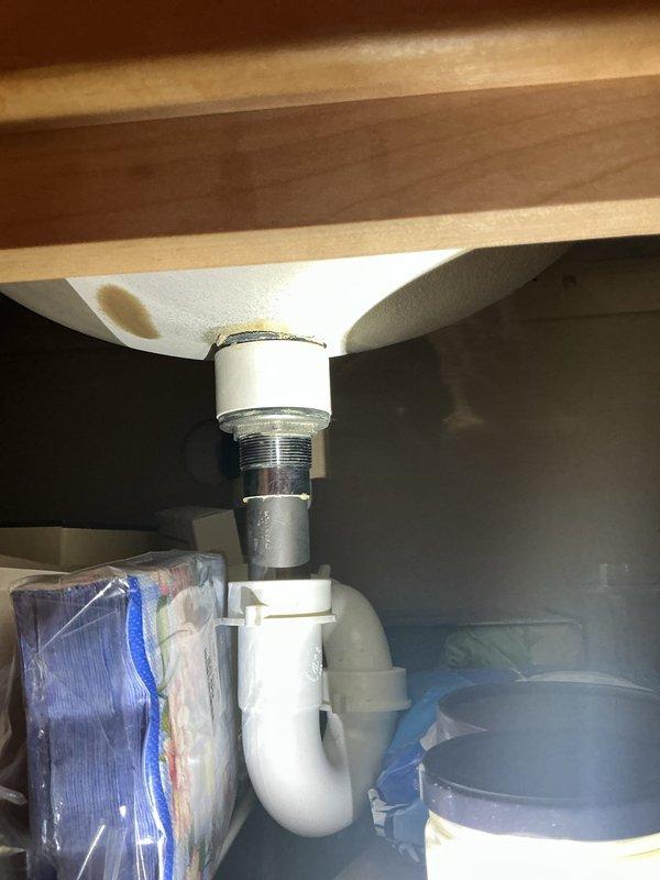Responded to service call for slow-draining bathroom sinks. Upon arrival, inspected the plumbing system beneath the affected fixtures and examined the P-trap assembly and drain connections. The white PVC P-trap showed signs of typical residential use and required attention to restore proper drainage flow. Performed cleaning and maintenance procedures to remove accumulated debris and buildup causing the drainage restriction. Verified all connections were secure and properly sealed. Tested water flow after service completion to confirm drainage had returned to normal operating speed. System is now functioning as intended with no further drainage issues observed.