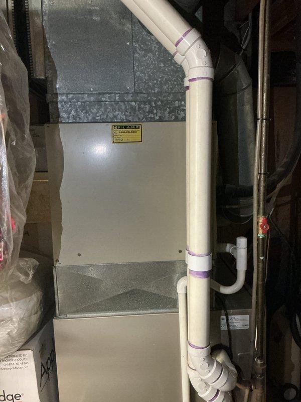Completed comprehensive assessment of existing HVAC system utilizing R22 refrigerant for full system replacement estimate. Evaluated indoor air handler unit located in basement utility area and documented current equipment configuration, including furnace assembly, PVC condensate drainage system, and associated ductwork. Inspected outdoor condensing unit mounted on exterior brick wall near building foundation, noting electrical connections and drainage components. Provided detailed equipment replacement recommendations due to obsolete R22 refrigerant system, including specifications for modern high-efficiency heating and cooling equipment compatible with current environmental standards.