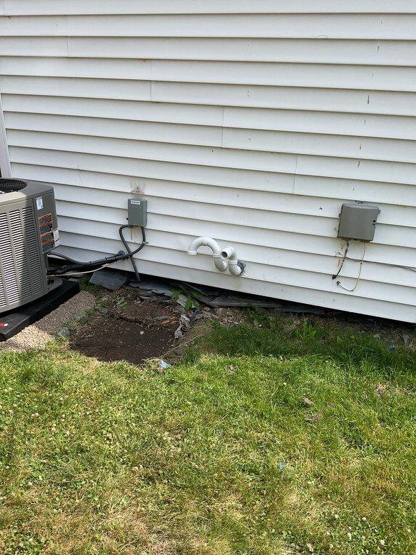 Completed full HVAC system installation including a 70,000 BTU furnace, 2-ton air conditioning unit, programmable thermostat, and humidifier at residential property. Equipment was installed in rear yard location with condenser unit positioned on exterior wall alongside existing electrical service infrastructure. All electrical disconnects and conduit were properly installed and routed along exterior siding to meet code requirements. New PVC condensate drain lines were run through exterior wall for proper drainage. Mechanical, electrical, and furnace permits were obtained prior to installation. System was connected to existing ductwork and electrical service, with all reconnections completed per manufacturer specifications. Unit qualifies for utility company energy efficiency rebates and carries AHRI certification number 215663144. Final testing confirmed proper operation of heating, cooling, and humidification functions with all safety controls verified operational.
