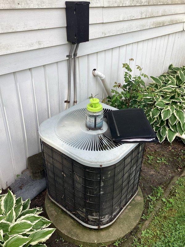 Conducted comprehensive assessment of 35-year-old residential HVAC system for complete replacement estimate. Evaluated outdoor air conditioning condenser unit positioned on concrete pad against exterior wall with existing electrical disconnect and PVC drainage, noting advanced age and condition of equipment. Inspected basement furnace installation, documented existing electrical service configuration with dual meter setup, and photographed current system components to provide accurate replacement specifications for both heating and cooling equipment.