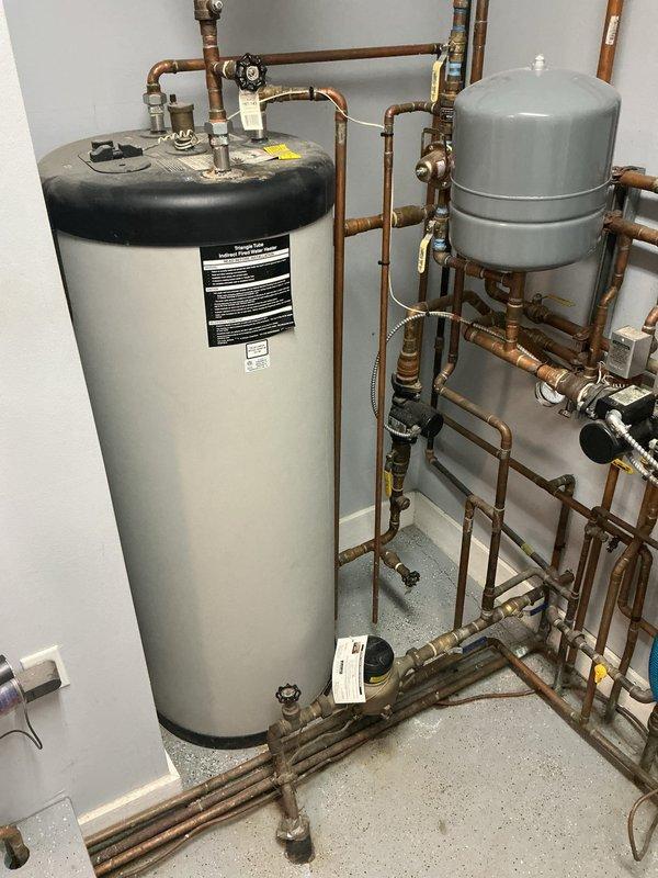 Conducted on-site evaluation for boiler replacement in residential basement mechanical room. Existing 15-year-old boiler system assessed, including current hydronic heating configuration with copper piping network, expansion tank, and associated plumbing components. Documented current installation layout featuring wall-mounted boiler unit with PVC exhaust/intake venting, multiple zone valves, pressure relief components, and connection points throughout the distribution system. Photographed existing equipment specifications, piping arrangements, and mechanical room conditions to prepare comprehensive replacement estimate for new boiler installation.
