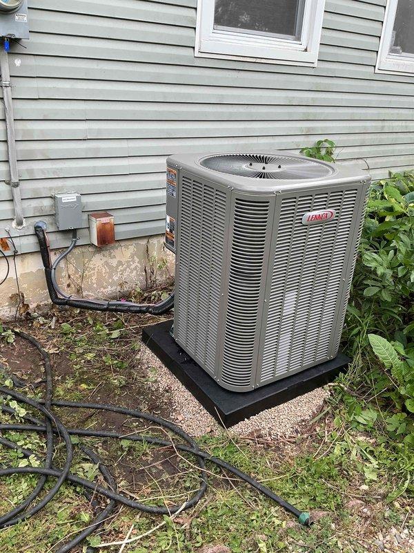 Completed full installation of 2-ton Lennox air conditioning system with matching evaporator coil at rear of residence. Installed new outdoor condensing unit on protective pad with proper refrigerant line set and electrical connections, including disconnect box and electrical conduit. Reconnected existing humidifier to new system. Charged system with R-454B refrigerant and verified proper operating pressures and temperatures using digital manifold gauges. System tested and confirmed operational with appropriate superheat and subcooling values. All mechanical and electrical permits requested and documentation completed.