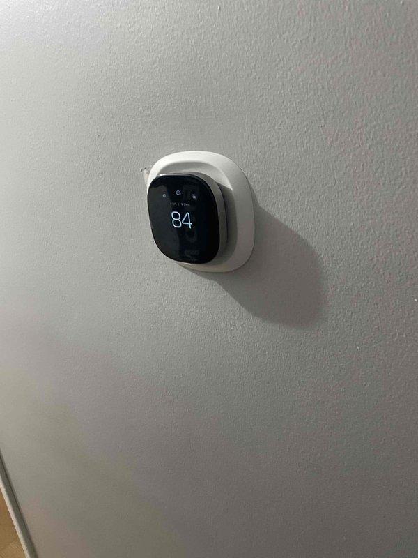 Provided comprehensive estimate for complete air conditioning system replacement for aging 10+ year old unit located in basement. Assessed existing equipment configuration including dedicated A/C electrical disconnect, evaluated natural gas furnace compatibility for new system installation, and documented current thermostat setup displaying 84°F ambient temperature. Presented replacement options and pricing for new cooling system to address customer's inquiry regarding available equipment packages.