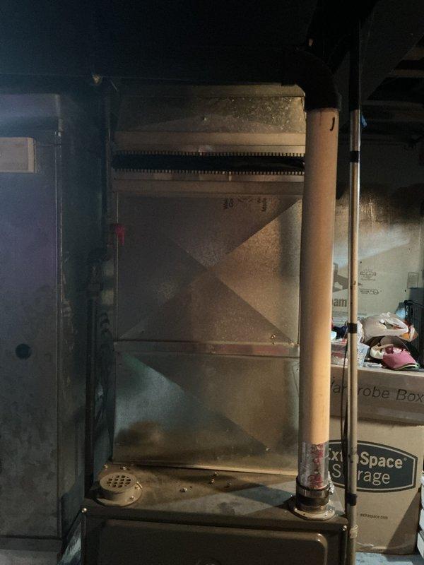 Performed comprehensive assessment of 15-year-old air conditioning system located in basement that was blowing air but not producing cold air, affecting entire home. Documented existing equipment condition through photographic evidence showing aged HVAC unit with visible wear, dust accumulation, and deteriorating components including heat exchanger with metallic fins. Provided replacement estimate for complete system due to age and failure to cool, with customer enrolling in maintenance plan for two pieces of equipment.